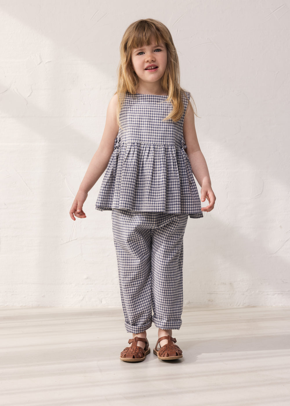 Barn iført ternet top med peplum og matchende bukser