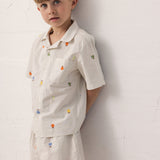 Barn iført skjortesæt med frugtbroderi og matchende shorts