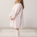 Barn iført lyserød kjole med løs pasform