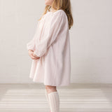 Barn iført lyserød kjole med løs pasform