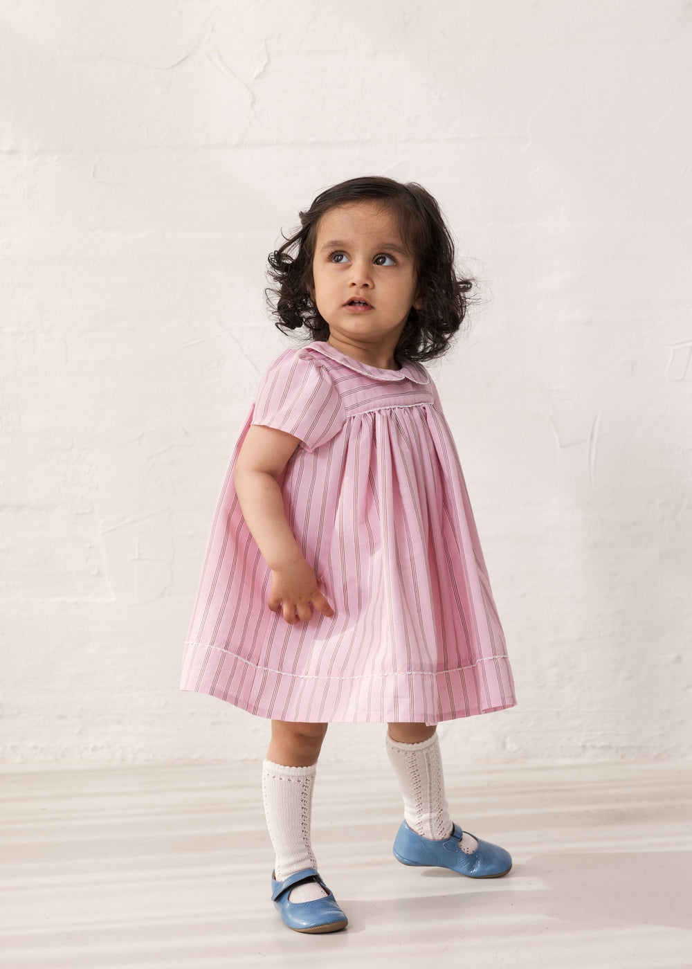 Baby pige i lyserød kortærmet kjole med fine striber og picotkanter