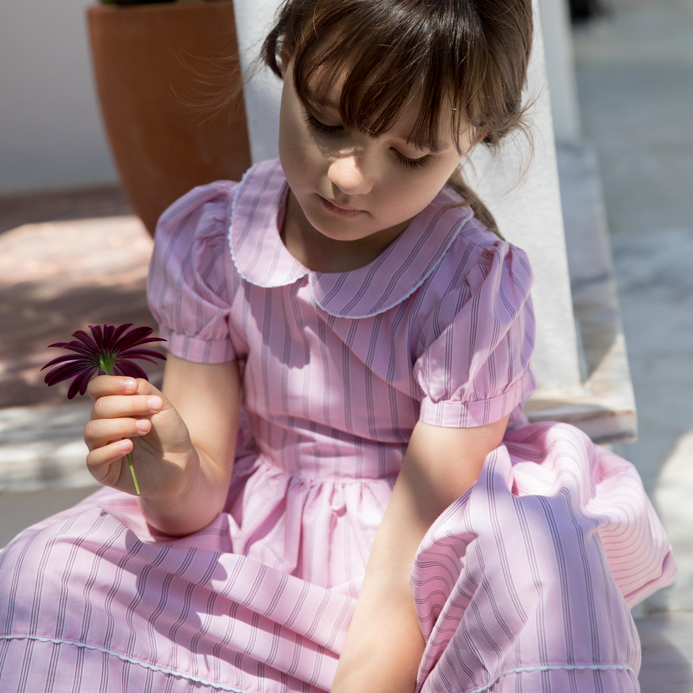 Pige i lyserød kjole med striber