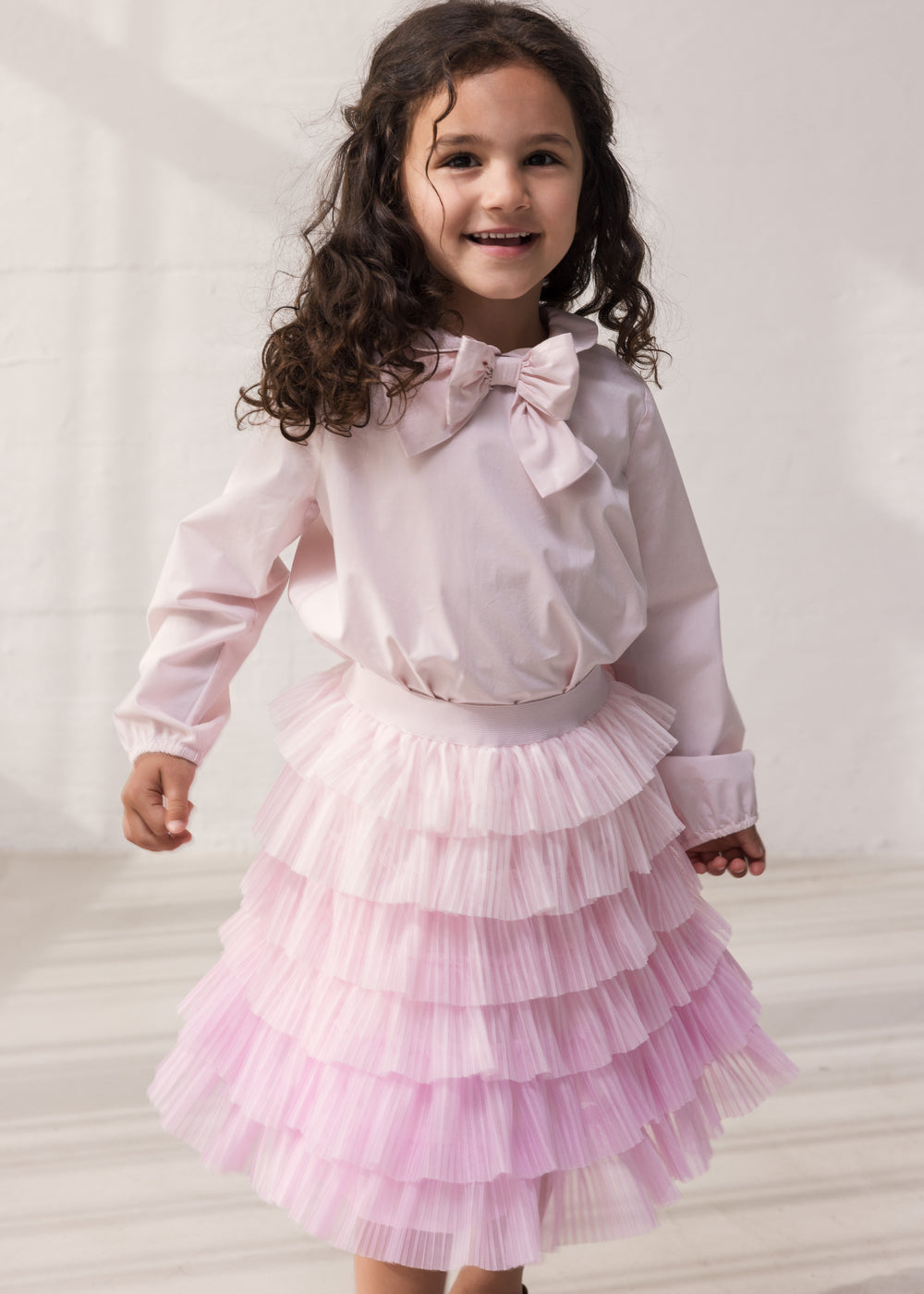 Barn iført lyserød bluse og tyls nederdel med flere lag