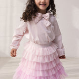 Barn iført lyserød bluse og tyls nederdel med flere lag