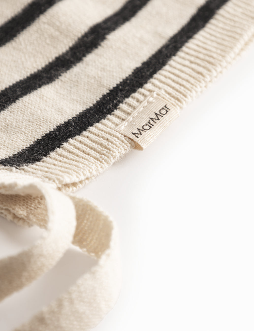 Stribet babyhjelm i råhvid og sort med bindebånd