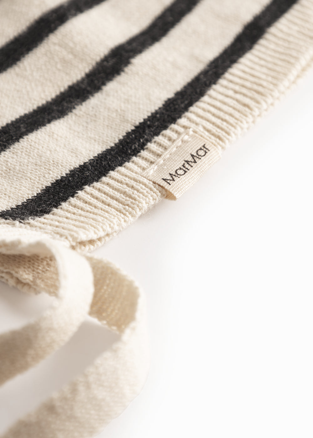 Stribet babyhjelm i råhvid og sort med bindebånd