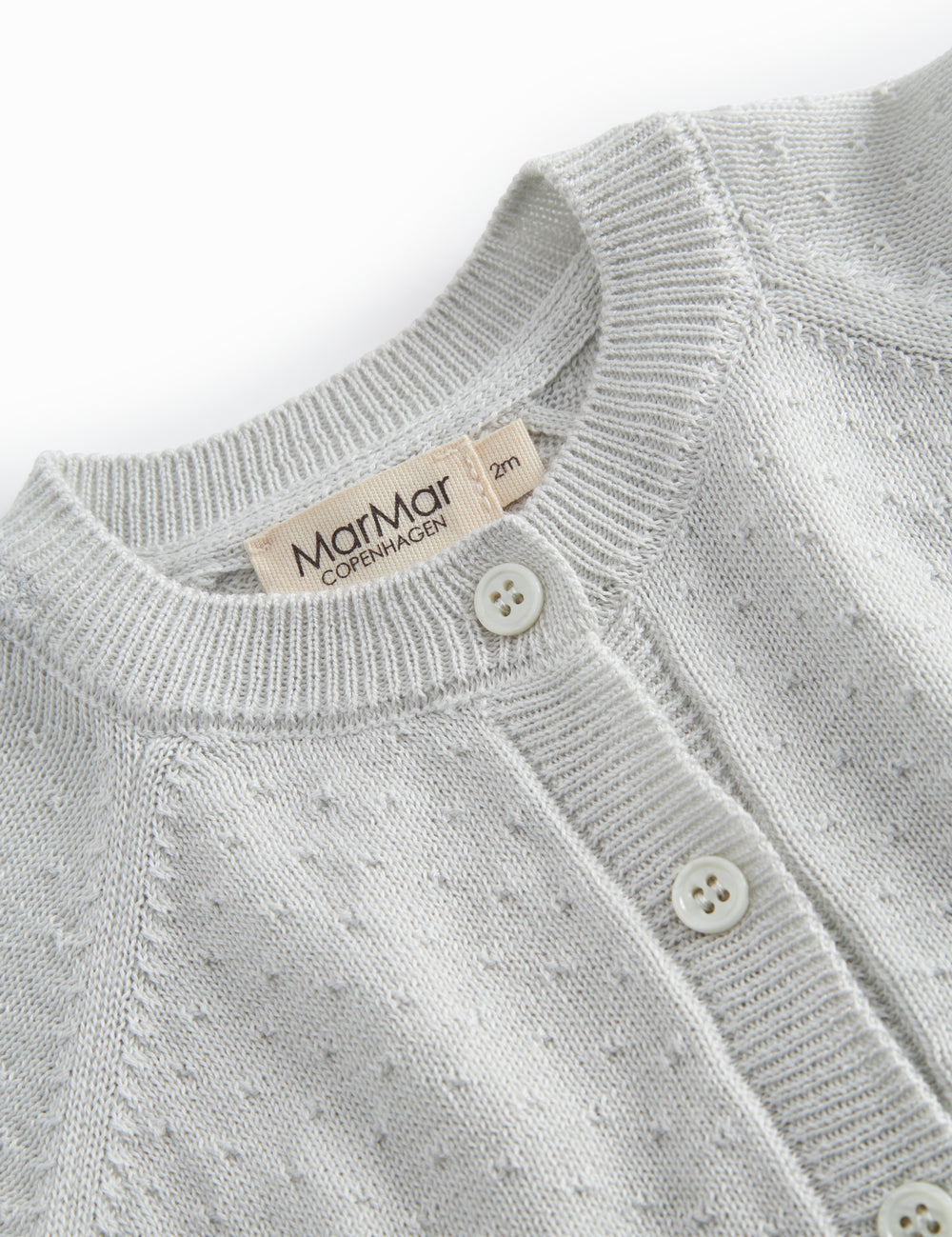 Lysegrøn strik cardigan til baby, med fint hulmønster og knaplukning