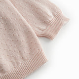Lyserød strik cardigan til baby, med fint hulmønster og knaplukning