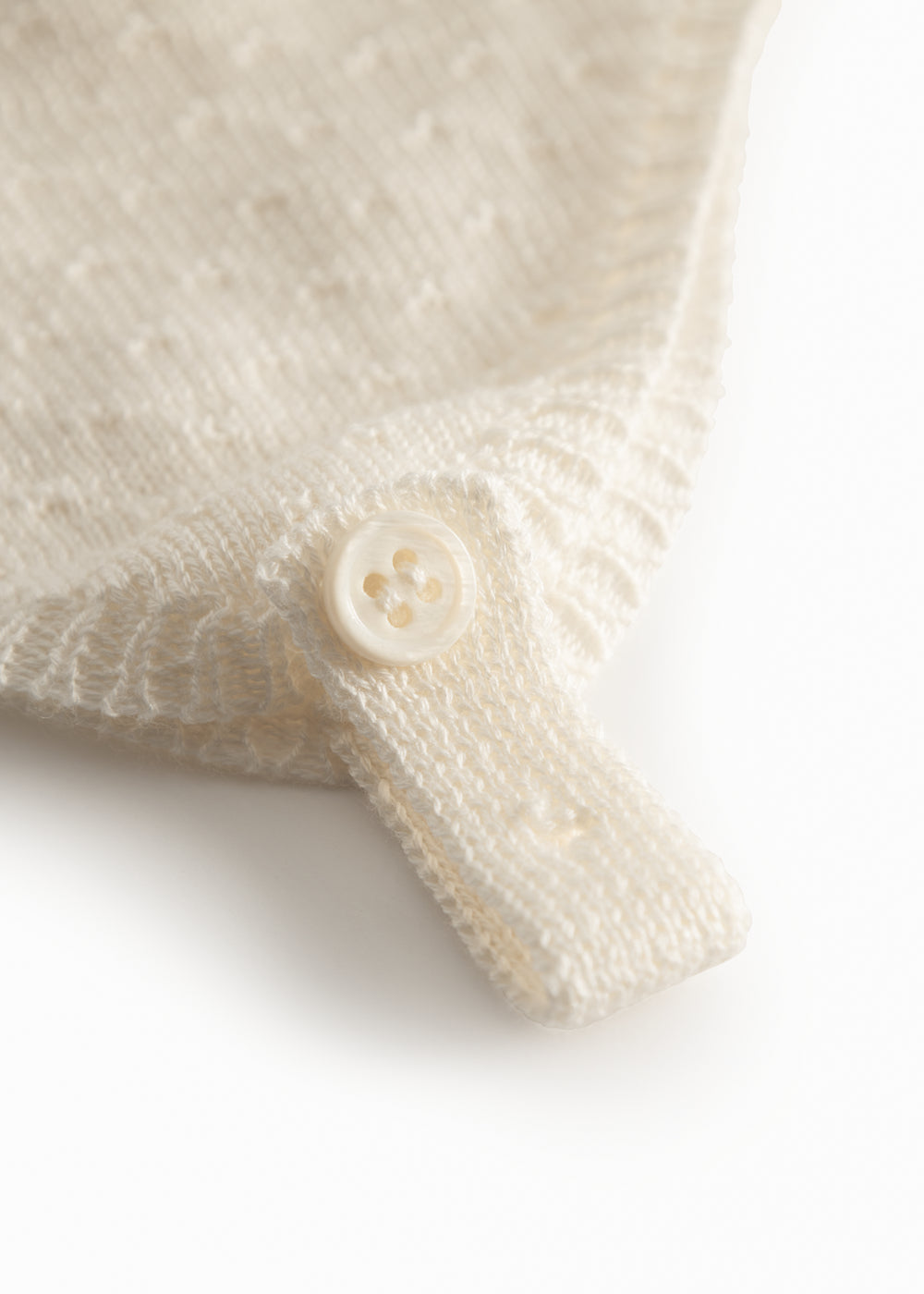 Strikket babyhue i råhvid med knaplukning