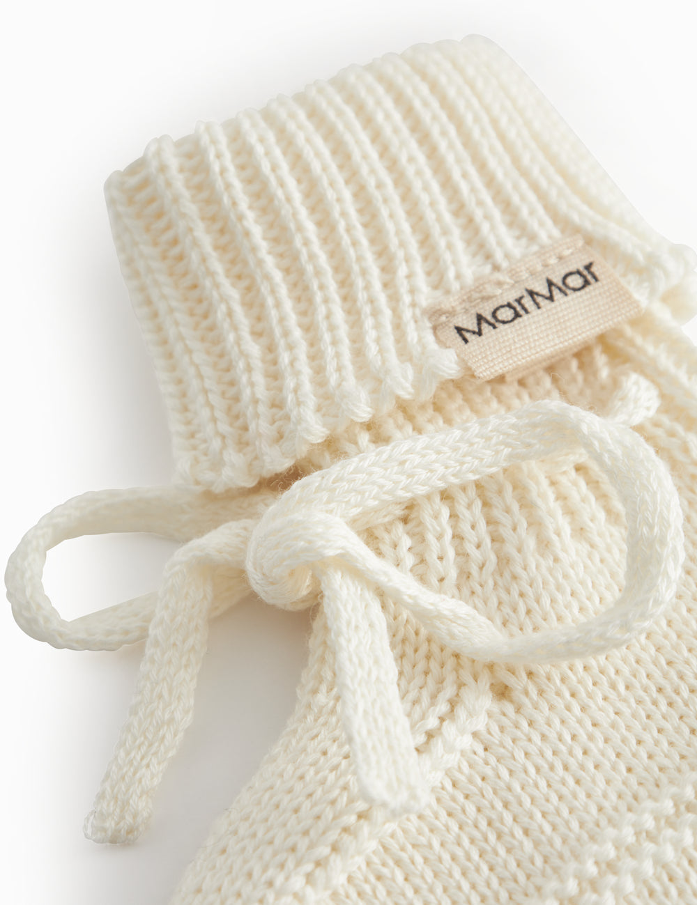 Strikkede babyfutter i råhvid med ribkant og bindebånd