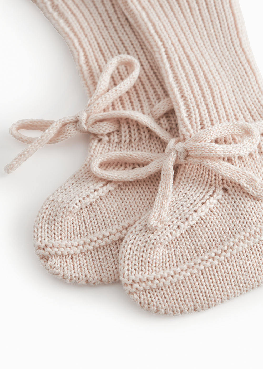 Strikkede babyfutter i lyserød med ribkant og bindebånd