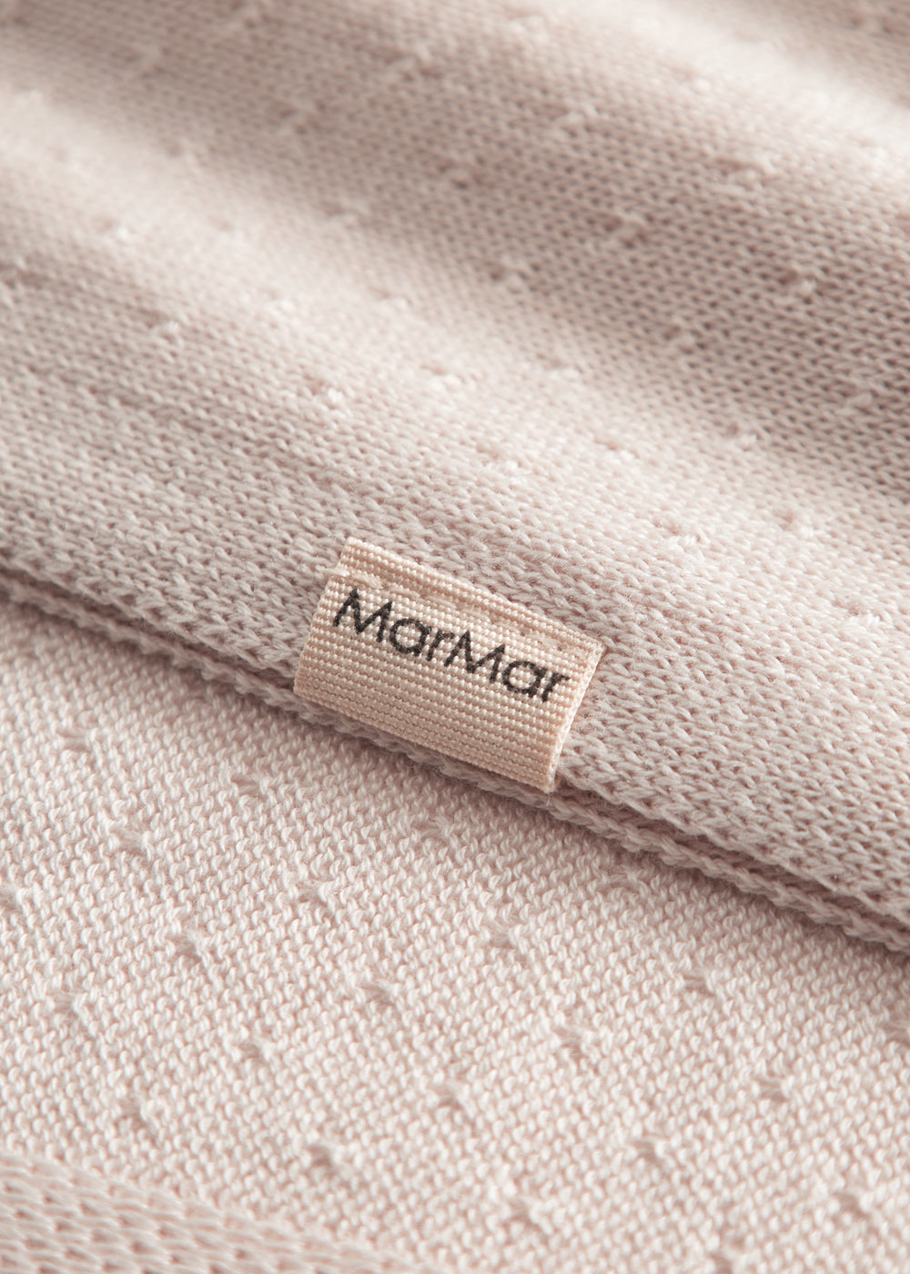 Lyserød baby striktæppe med hulmønster