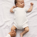 Baby der sover i hvid heldragt uden ben med fint mønster