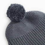 Grå strikhue med pompom og ribbet strikkanter