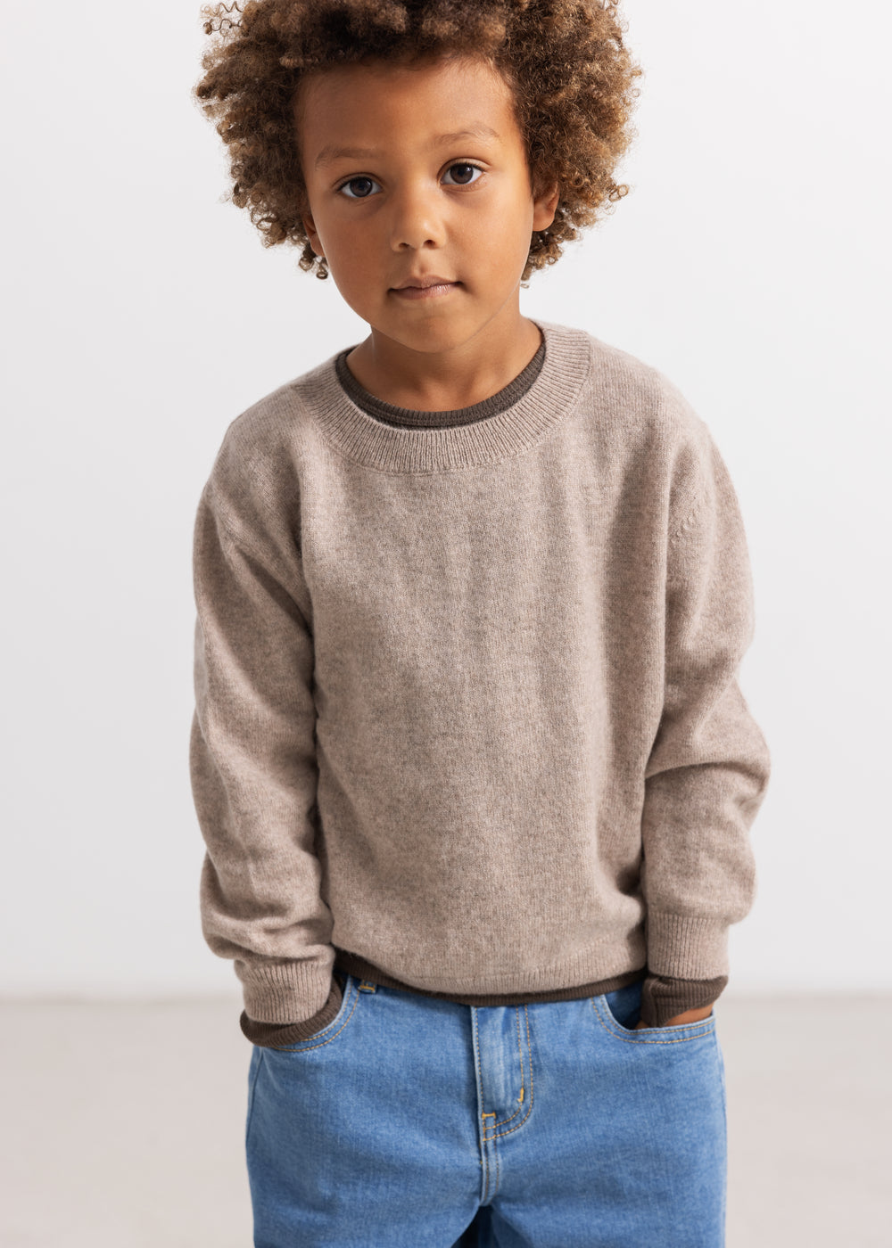 Grå meleret strikbluse med rund hals og ribkanter, båret til blå jeans