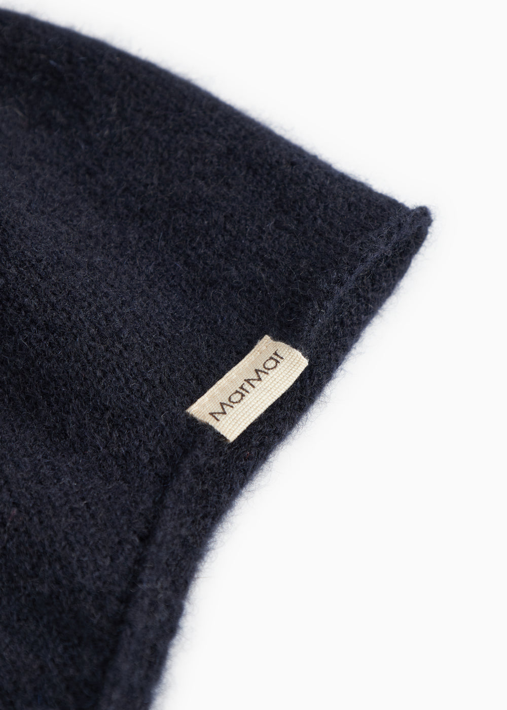Babyhue i mørk indigo strik med mærkelabel på kanten