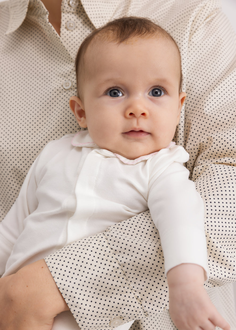 Baby i off-white heldragt med krave og lange ærmer, heldækkende ben