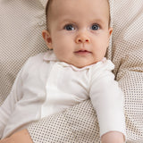 Baby i off-white heldragt med krave og lange ærmer, heldækkende ben