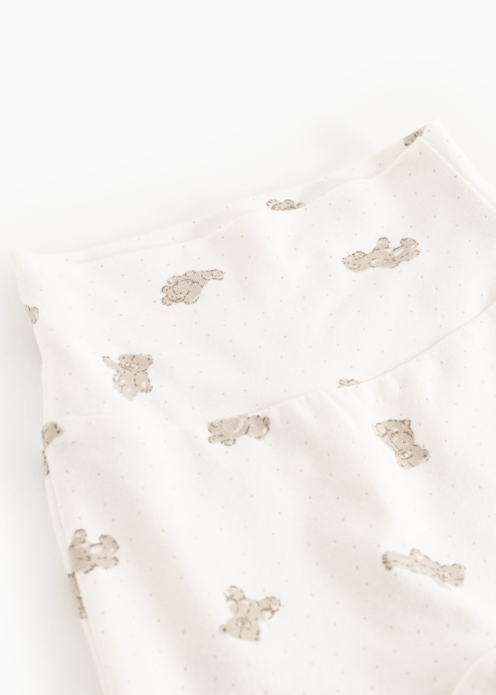 Detalje af creme babybukser med gentaget teddybjørneprint