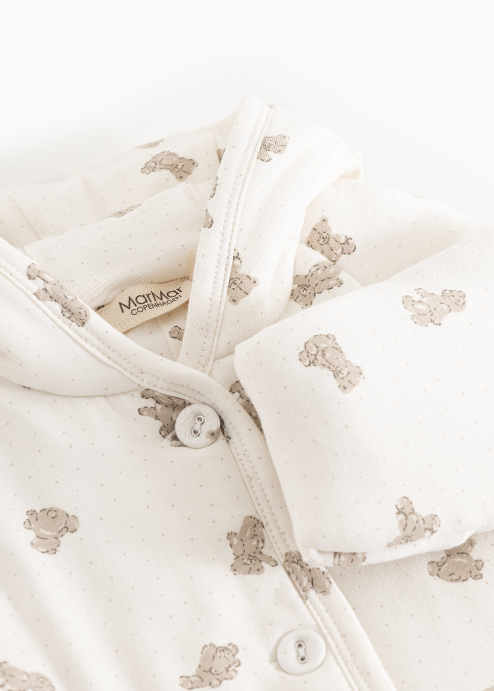 Hvid heldragt med beige teddybjørneprint, hætte og knaplukning ved halsen