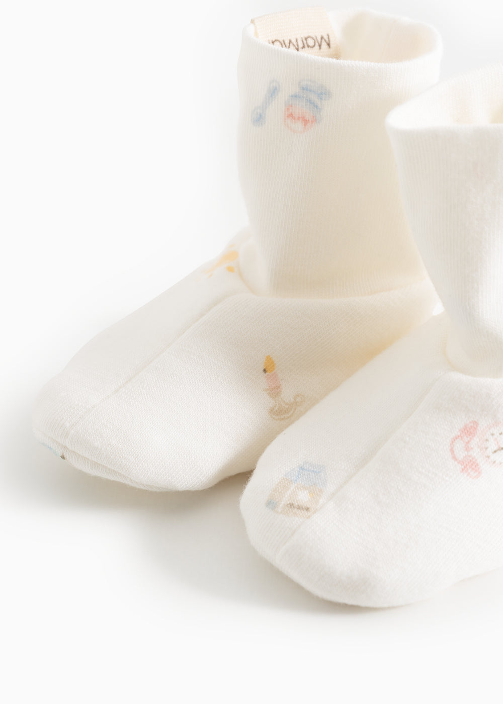 Babystøvler i creme med korte, fyldige manchetter og broderede små figurer