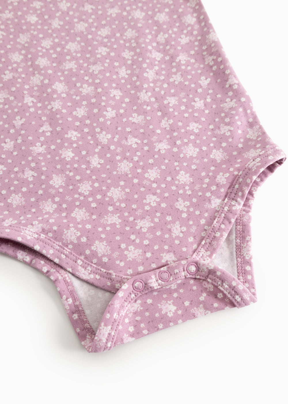 Rosa bodystocking med blomsterprint og trykknapper ved skridtet