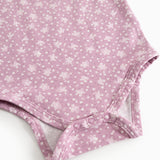 Rosa bodystocking med blomsterprint og trykknapper ved skridtet