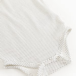 Baby-bodystocking med små sorte prikker, lange ærmer og knapper ved ben