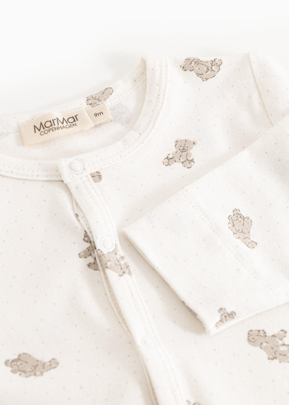 Heldragt med off-white bund og teddybjørneprint, trykknaplukning ved hals