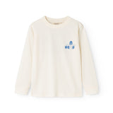 Langærmet bluse i creme med blåt “Hello” print på brystet.