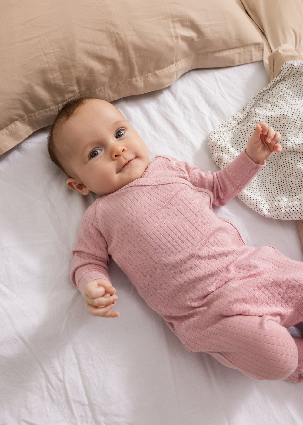 Lyserød babyheldragt med lange ærmer og ribbet mønster