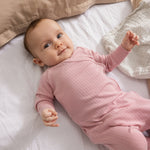 Lyserød babyheldragt med lange ærmer og ribbet mønster