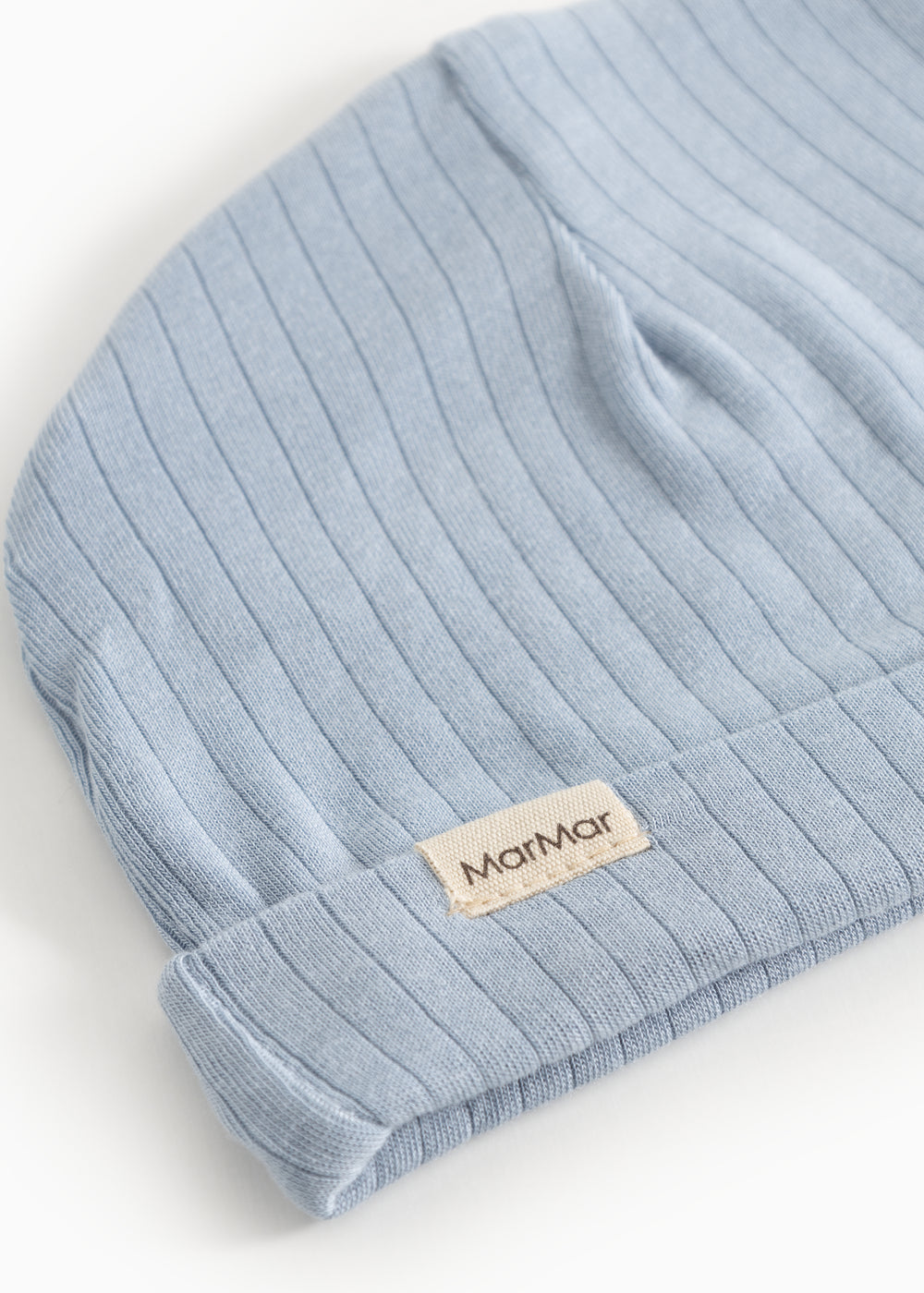 Blå strikhue i ribstrik med beige logoetiket på manchet