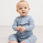 Lyseblå heldragt med knaplukning, båret af baby i helfigur