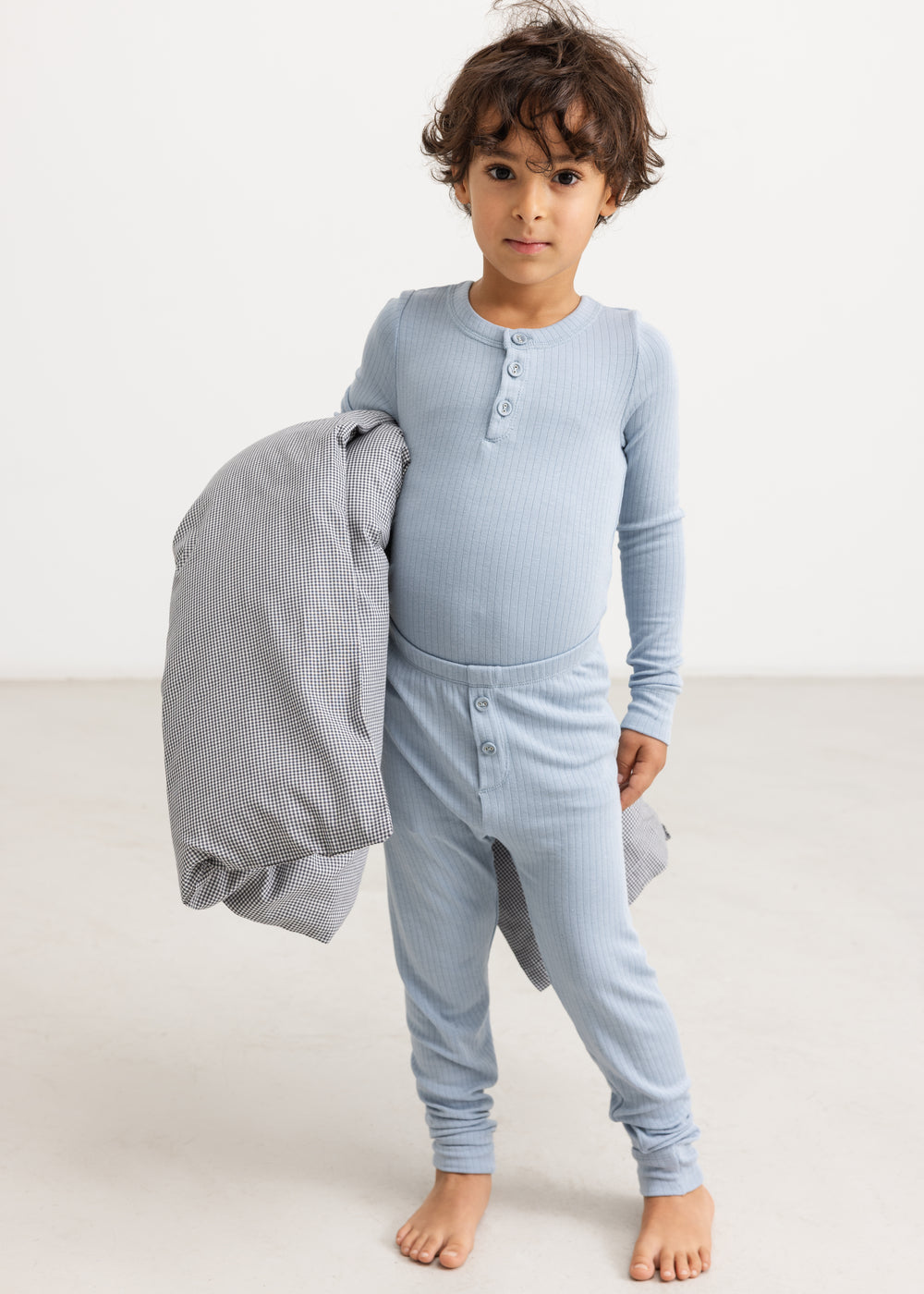Lyseblå lange leggings på barn, ribbet stof og knaplukning foran.