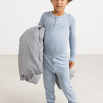Lyseblå lange leggings på barn, ribbet stof og knaplukning foran.