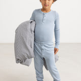 Lyseblå lange leggings på barn, ribbet stof og knaplukning foran.