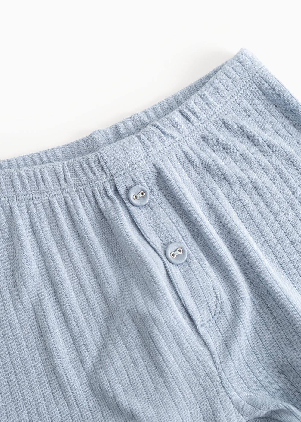 Lyseblå lange leggings med elastiklinning og to knapper foran.