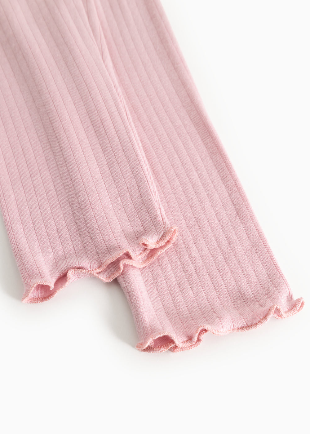 Lyserøde leggings med ribstrik og frynsekant ved anklen, elastisk og let fald.
