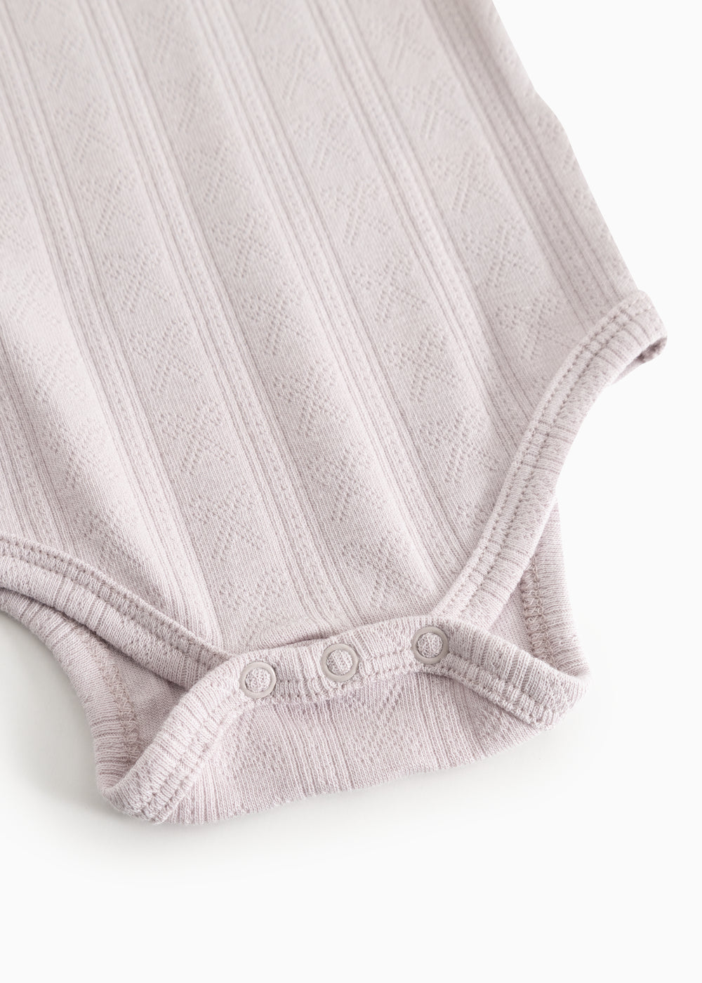 Babybody i lys lilla med trykknaplukning ved skridtet og ribkant