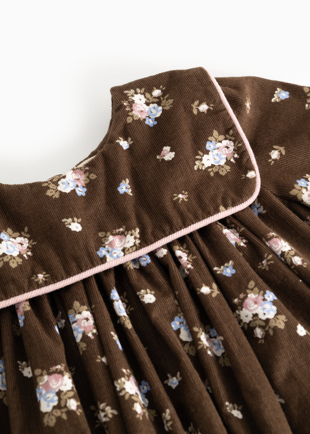 Dulle kjole med blomsterprintet bryst og rund krave samt lys kant omkring åbning