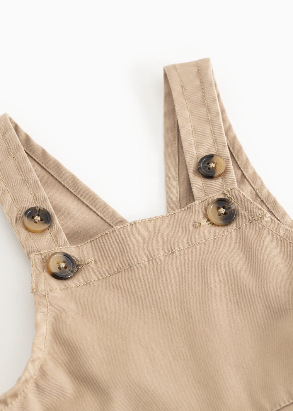 Beige selebukser med krydsede seler, metalknapper og dobbeltsøm.