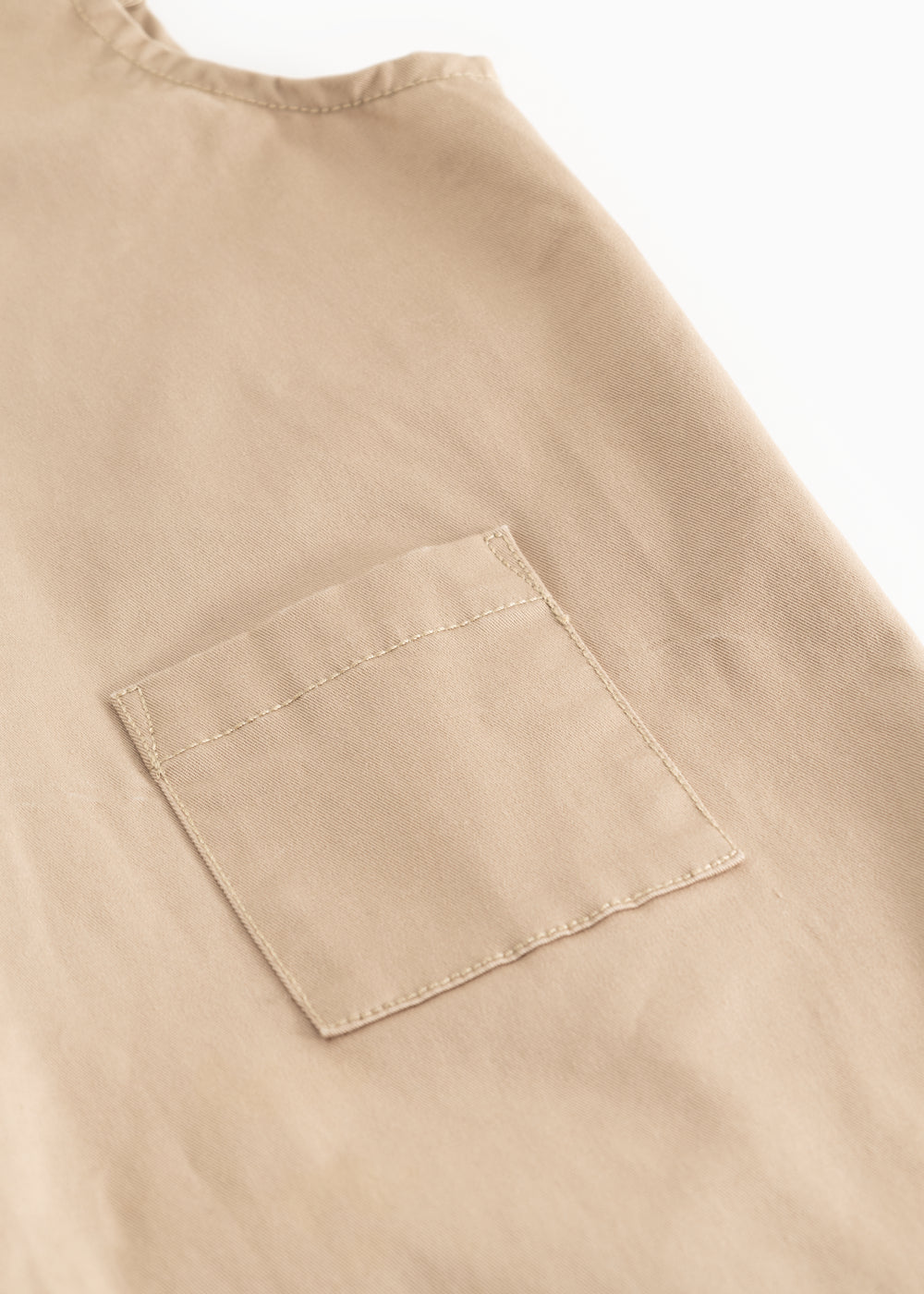 Beige selebukser til baby med forlommelomme og stikninger.
