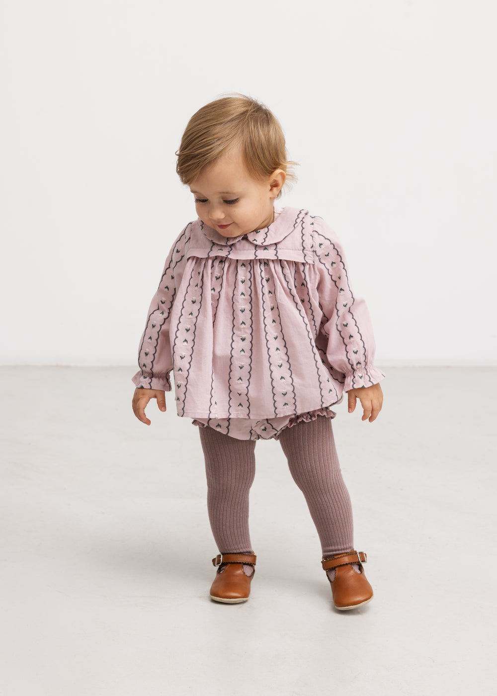 Barns støvede lilla bloomers med lodrette mønsterstriber og volang ved ben.