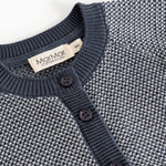 Detalje af strikket cardigan med knaplukning og rund halsudskæring i rib