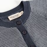 Detalje af strikket cardigan med knaplukning og rund halsudskæring i rib
