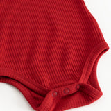 Kirsebærrød bodystocking med ribmønster og trykknapper ved skridtet.