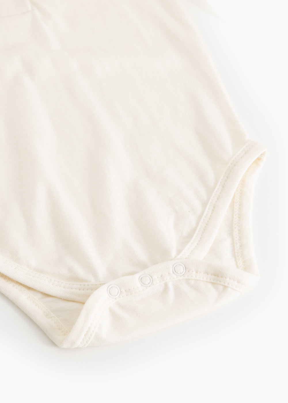 Hvid bodystocking set nedefra med trykknapper ved skridtet