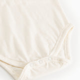 Hvid bodystocking set nedefra med trykknapper ved skridtet
