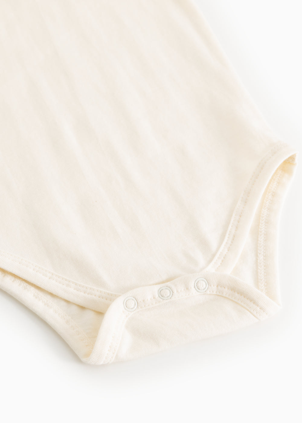 Hvid bodystocking med rød kravebroderi og trykknapper ved benåbning